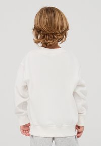 Felpa bianca con collo rotondo, spalle cadute, polsini a costine e orlo a costine. Texture liscia, senza motivi o dettagli visibili.