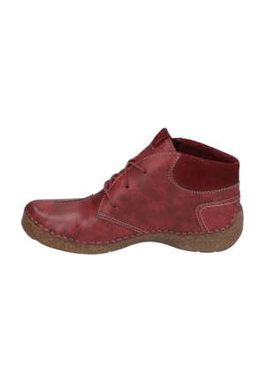 Red leather ankle boot with rounded toe, lace-up design, soft suede accents, and textured cork sole. Side stitching adds detail.