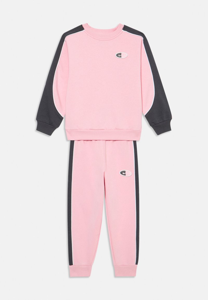 Rózsaszín pulcsi és nadrág készlet sötétszürke részletekkel, bordázott mandzsettával, valamint hímzett logóval a mellkasán és a combján. Sima textúra.