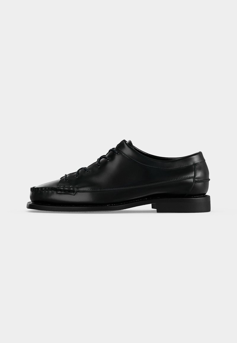 Chaussure habillée noire en cuir à lacets, talon bas et coutures moc toe, vue de profil gauche sur fond uni.