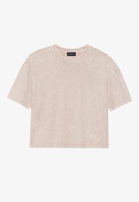 Lys beige cropped t-skjorte laget av myk bomull. Har rund halslinning, korte ermer og en avslappet passform med subtil tekstur.