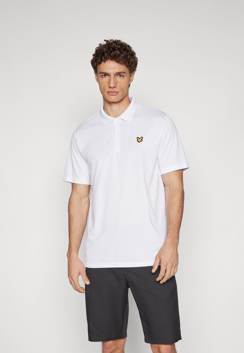White polo shirt with a collar, short sleeves, and a yellow butterfly logo on the left chest. Paired with dark shorts.