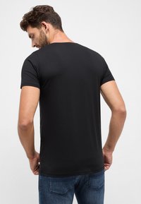 Zwart t-shirt met korte mouwen en ronde hals, gemaakt van soepel katoen. Kenmerkt zich door een ontspannen pasvorm en schone naadtoeslagen.