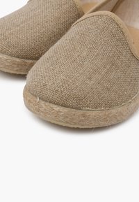 Espadrillas beige con toma a slip-on, realizzate con un'estremità in tessuto testurizzato e suola in juta. Presentano un tallone chiuso e un design a punta rotonda.