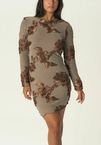 Robe à manches longues en vert olive avec broderie florale marron. Présente une coupe cintrée et un ourlet effiloché, mettant en valeur des textures et des détails raffinés.
