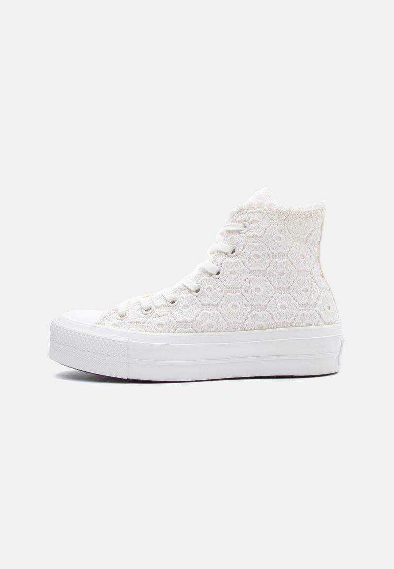 Hvid høj-top sneaker med blomstret snøremønster, gummisål og hvide snørebånd på en ensartet lys baggrund.