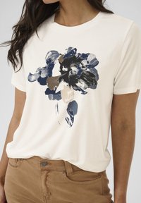 Kurzärmliges weißes T-Shirt mit großem navy-, braun- und cremefarbenem Blumenmuster auf der Vorderseite, aus weichem Baumwollmaterial gefertigt.