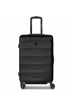 Valise rigide noire avec poignée télescopique déployée et quatre roues multidirectionnelles, posée à la verticale sur fond blanc.