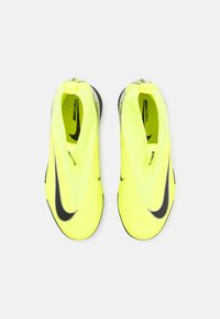 Bottes de soccer jaunes vives avec un design élégant, une texture lisse, des accents noirs et un logo. Offre un ajustement parfait sans lacets.