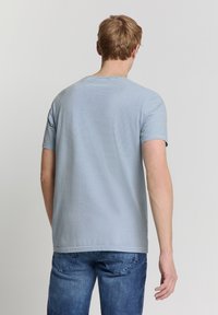 Korte mouwen blauw gestreept t-shirt gemaakt van katoen, met een ronde hals en een ontspannen pasvorm, gecombineerd met donkerblauwe jeans.