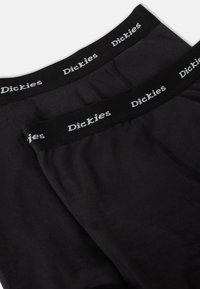 Fekete boxer alsónemű, puha anyagból készült, fekete derékpánttal, fehér "Dickies" logóval, sima textúrával és testhez álló kialakítással.