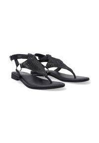 Sorte flade sandaler med en thong-design, der har teksturerede mesh-detaljer, ankelrem og minimal hardware. Sålen er glat og flad.
