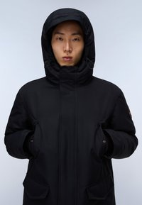 Černá péřová bunda s vysokým límcem a kapucí. Obsahuje přední kapsy a bezpečné zapínání na zip. Hladká, voděodolná tkanina.