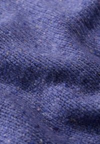 Ulltyg i olika nyanser av blått och lila, med en strukturerad väv som har inslag av ljusare färger här och där.