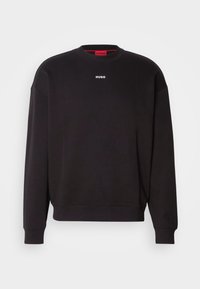 Sweat-shirt noir à col rond avec manches longues, poignets et bas côtelés, et petit logo blanc "HUGO" centré sous l'encolure.