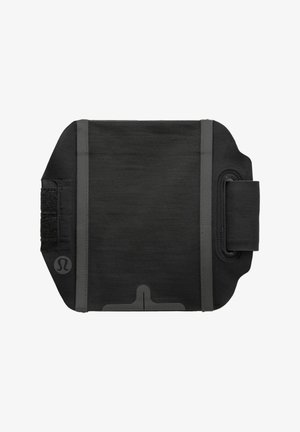 Brazalete de fitness de tela negra con superficie texturizada, correa ajustable y un logo en el lateral. Presenta un acabado suave y un diseño resistente.