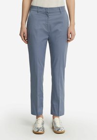 Ljust blå skräddarsydda byxor i ett mjukt tyg. Rakt ben-design med midjehåls-höjd och sidofickor. Kapade vid anklarna.