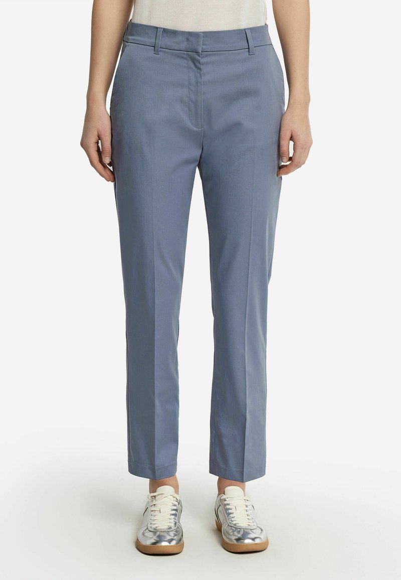 Ljust blå skräddarsydda byxor i ett mjukt tyg. Rakt ben-design med midjehåls-höjd och sidofickor. Kapade vid anklarna.