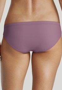 Bas de bikini violet avec une texture lisse, arborant un design taille basse et des détails de couture minimalistes. Le tissu semble extensible et ajusté.