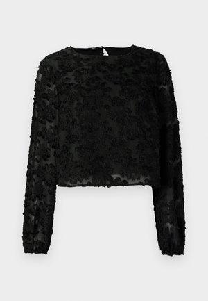 Melna īsā blūze ar garām piedurknēm, izšūtām ziedu motīviem, apaļu dekoltē un caurspīdīgu audumu. Redzama aizmugures aizdare.