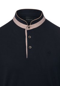 Granatowa koszulka polo z kontrastującym jasnym kołnierzem, trzyguździstą plisą, fakturowaną tkaniną i haftowanym logo na piersi.