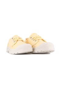 Baskets en toile jaunes avec une semelle en caoutchouc blanc texturé, dotées d'œillets en argent et de lacets assortis. Design à bout rond, style minimaliste.