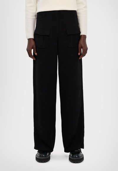 Wide-leg black cargo pants with two front pockets, made of soft fabric, featuring a loose fit and elastic waistband for comfort.