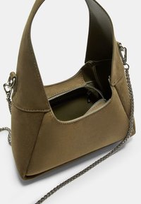 Olivengrøn suede taske med en struktureret form, åbent top og sølvfarvet kædrestrap. Har en lynlåslomme indeni til sikker opbevaring.