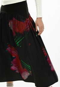 Must seelik, millel on liibuv vöökoht ja värvikad abstraktsed mustrid punases, rohelises ja roosas. Kerge kangas voolava disainiga.