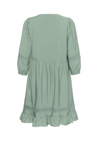 Robe vert clair longueur genou avec manches trois-quarts, bordure en dentelle sur les manches et l'ourlet, et bas à volants.