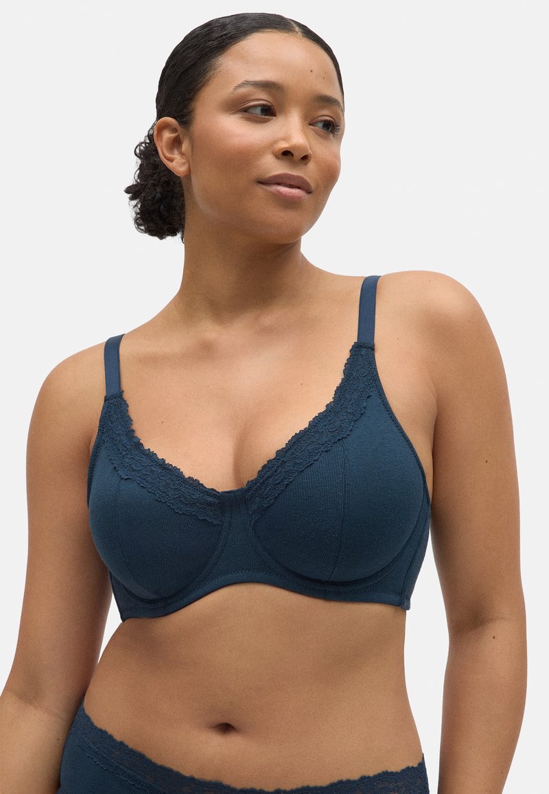 Sostén en tono verde oscuro con delicado encaje en el escote, tejido suave al tacto, soporte con aros y tirantes ajustables.