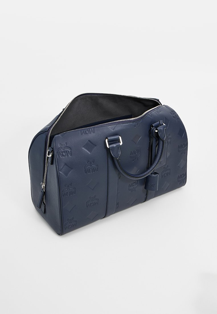 Navi blaue Leder-Duffle-Tasche mit geprägtem Logomuster, doppelten Griffen und einer glatten Oberfläche, mit einem Reißverschluss an der Oberseite.