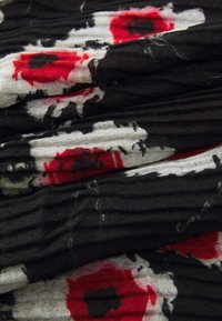 Tissu noir froissé avec des motifs floraux de coquelicot rouge et blanc, présentant une texture subtile. Design doux et léger.