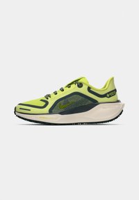 Nike løbesko med en lys gul mesh-overdel, sorte accenter og en polstret sål. Designet med struktureret greb og reflekterende detaljer.