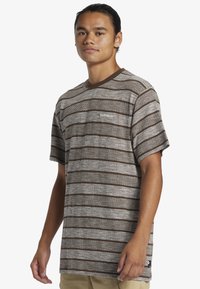 Bruin en crèmekleurig gestreept t-shirt met korte mouwen en een ronde hals, met een gestructureerd patroon en een klein logo op de borst.