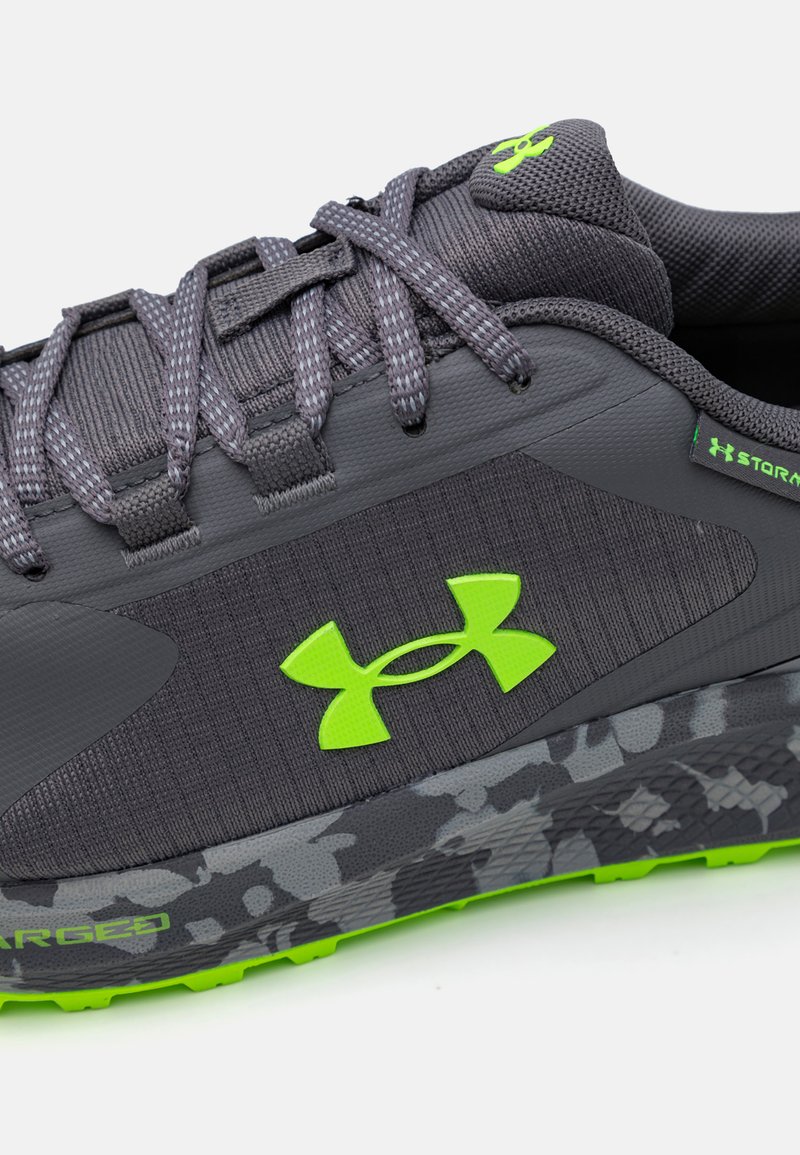 Szare buty sportowe z teksturowaną cholewką, akcentami w kolorze limonki i podeszwą w kamuflażu. Posiadają wyściełany kołnierz oraz sznurowany design.