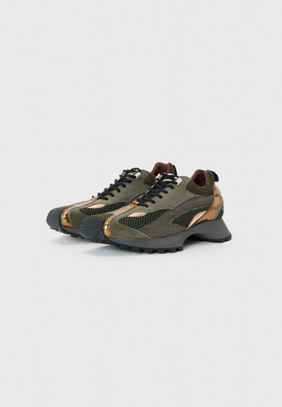 Grüne und bronzefarbene Sportschuhe aus Mesh- und Wildledermaterial, mit runder Zehenform, schwarzen Schnürsenkeln und strukturierten Gummisohlen.