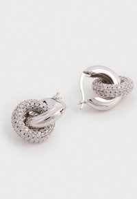 Pendientes de aro de plata con un diseño retorcido, superficie texturizada y pequeños rhinestones transparentes para un toque adicional de brillo.