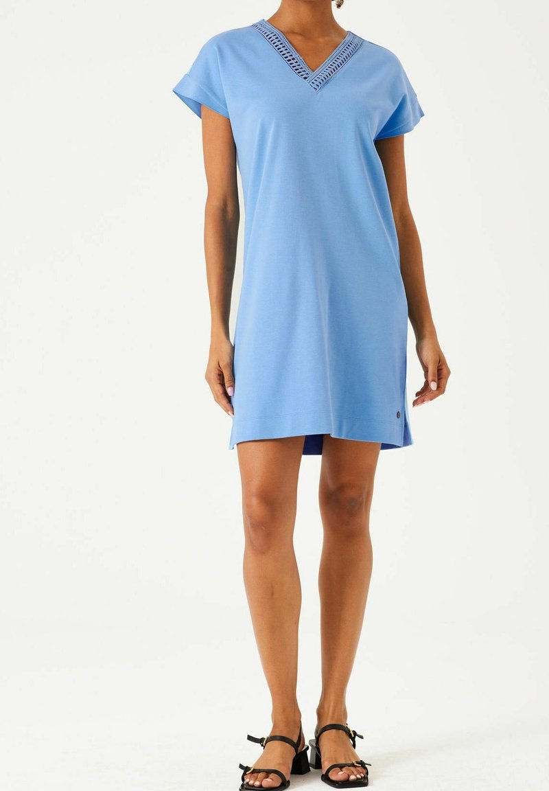 Robe bleu clair à manches courtes avec un décolleté en V et des détails en dentelle. Tissu doux et coupe décontractée, se terminant au-dessus du genou.