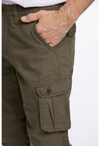 Olivgrüne Cargo-Hosen aus Baumwolle, mit seitlichen Taschen mit Klappen und Knöpfen sowie einer glatten Textur.