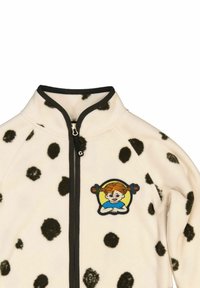 Fleece-takki mustilla pilkuilla vaalealla taustalla, vetoketjukiinnitys ja värikäs brodeerattu merkki, jossa on lettitukkainen tyttö.