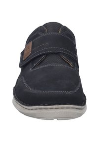 Schwarzer Wildlederschuh mit strukturiertem Obermaterial, ausgestattet mit einem Klettverschluss und kontrastierenden Nähten. Dicke, graue Gummisohle für Komfort.