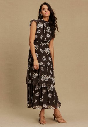 Brown floral maxi dress with ruffled shoulders, tiered layers, and a fitted waist. Features white and light purple floral patterns.