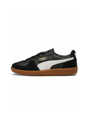 Sort-hvid Puma Palermo sneaker med gummisål, ruskind accents og gyldent Puma-logo på siden, vist i profil.
