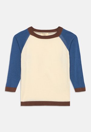 Camiseta raglán de manga larga con cuerpo color crema, mangas azules y ribete marrón en el cuello, los puños y el dobladillo, colocada plana sobre un fondo blanco.