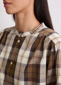 Checkered blouse featuring a mandarin collar, brown, beige, and gray plaid pattern, with button closures and gathered detailing at the shoulders.