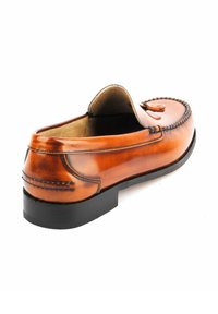 Brauner Lederloafer mit abgerundetem Zeh, dekorativer Naht und einer niedrigen schwarzen Gummisohle. Das Design umfasst ein Fransen-Detail an der Vorderseite.