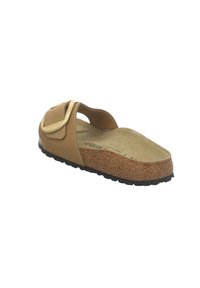 Sandale Birkenstock camel à bout ouvert avec semelle en liège et grande bride ajustable avec boucle sur fond blanc.