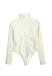 Bodysuit de cuello alto en color crema, fabricado en tejido suave con mangas largas, que presenta un diseño frontal único y una etiqueta de marca en el pecho.