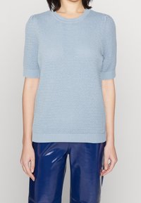 Suéter de punto de manga corta en azul claro con patrón texturizado, cuello y dobladillo acanalados. Combinado con pantalones anchos de imitación piel azules y brillantes.